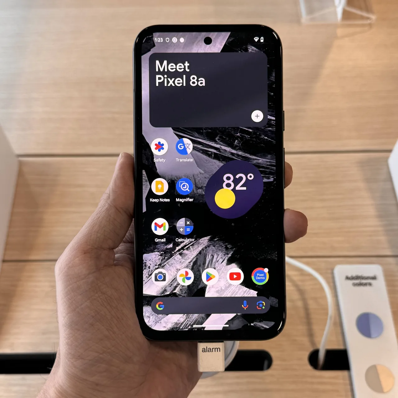 Téléphone Google Pixel 8a tenu en main dans un espace de présentation