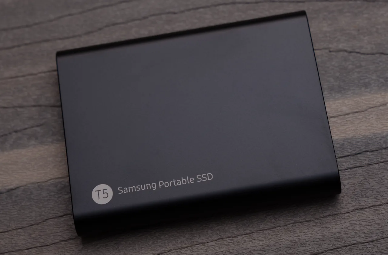 SSD externe portable Samsung T5 posé sur une surface en bois